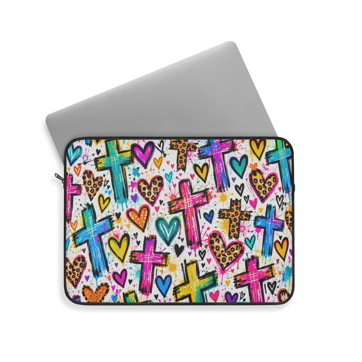 Colorful Christian laptop sleeve featuring bright graffiti-style crosses, pink and turquoise hearts, leopard-print accents, and vibrant paint splatters with black zipper trim.