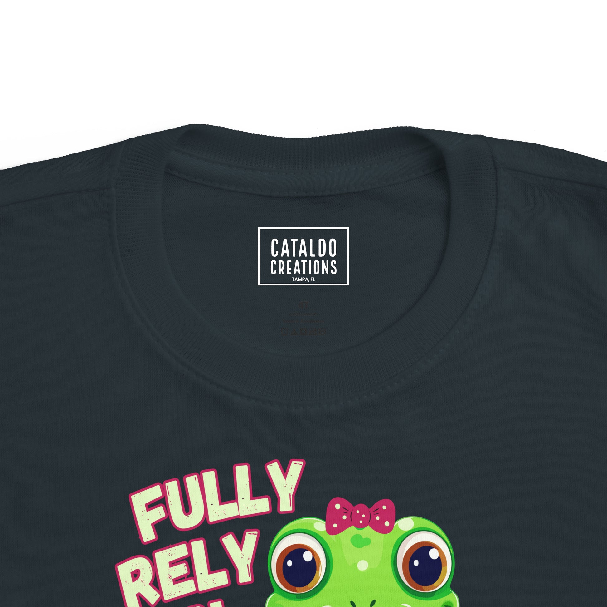 FROG. Fully Rely On God. This cute little girl toddler short sleeve t-shirt has an adorable green frog wearing a pink bow.&nbsp; Alongside are the words Fully Rely On God in light green and pink lettering. Perfect for your toddler girl! Christian toddler tee. Cataldo Creations apparel for toddlers