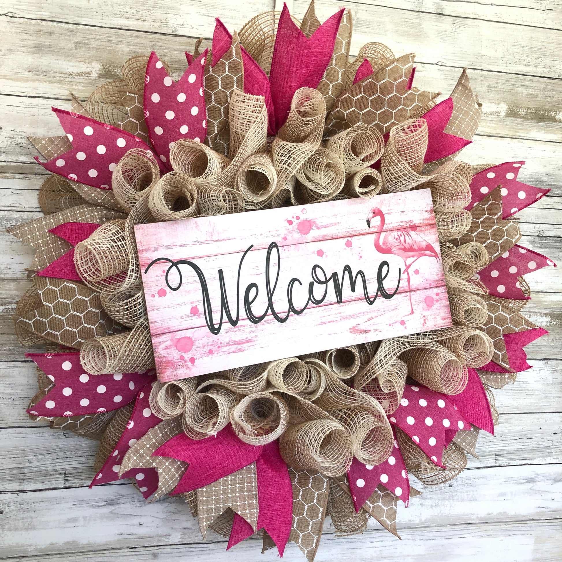 Welcome guests to your home with a touch of whimsy and warmth with our Flamingo Pink Welcome Door Wreath! Featuring a charming flamingo design and delicate pink and beige accents, this handmade wreath is the perfect way to make your entrance inviting.