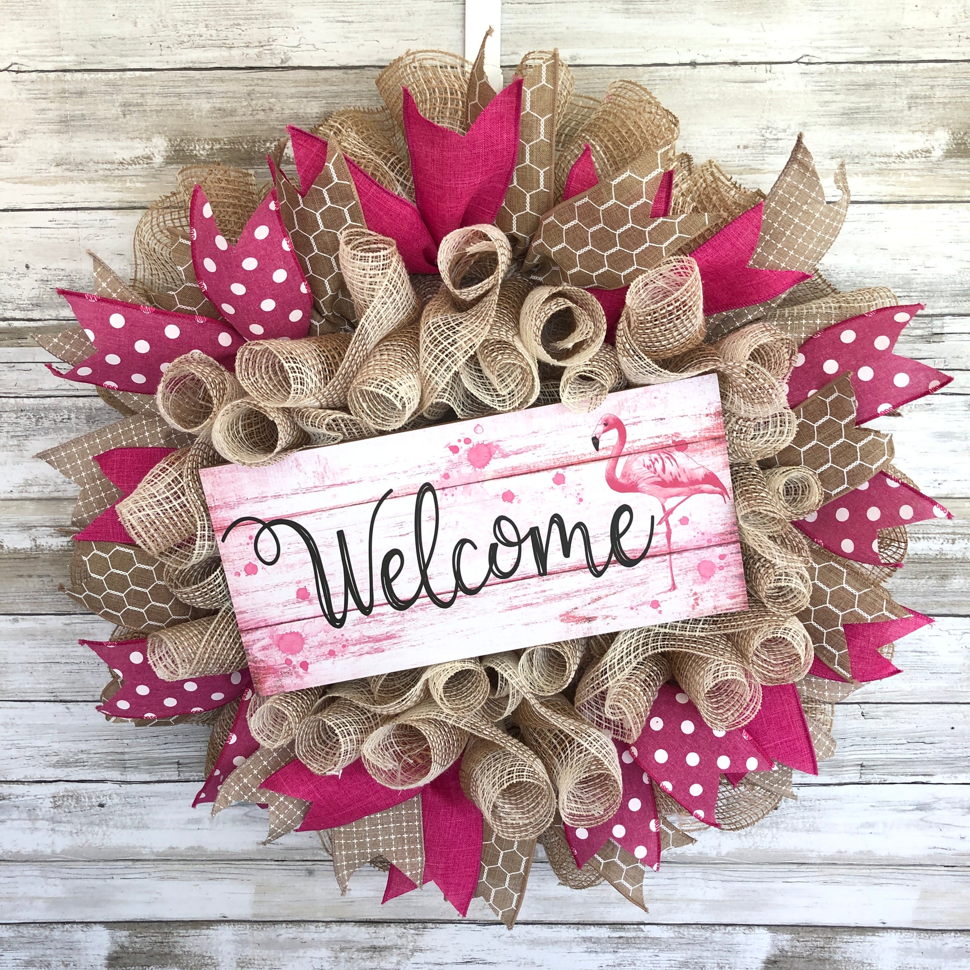 Welcome guests to your home with a touch of whimsy and warmth with our Flamingo Pink Welcome Door Wreath! Featuring a charming flamingo design and delicate pink and beige accents, this handmade wreath is the perfect way to make your entrance inviting.