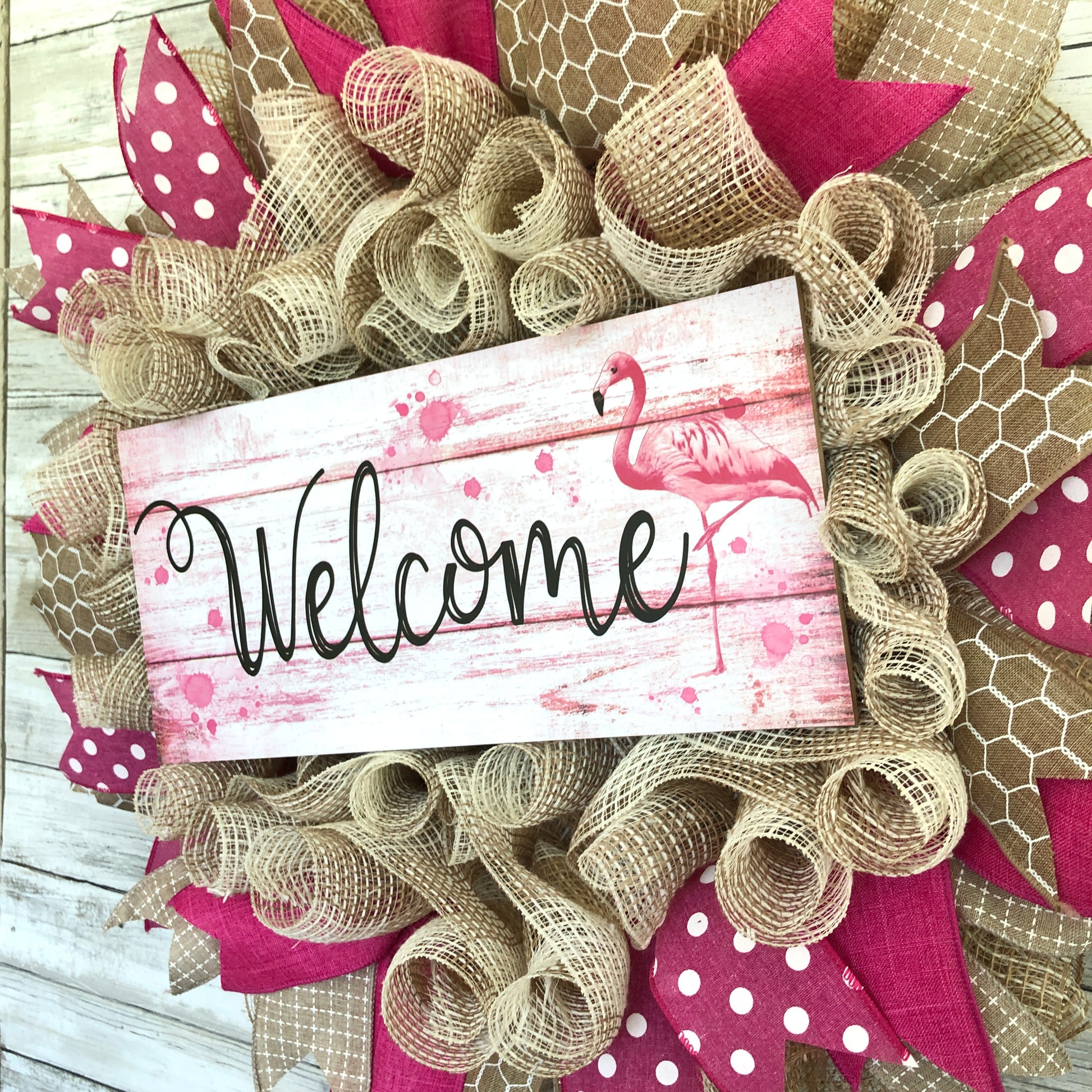 Welcome guests to your home with a touch of whimsy and warmth with our Flamingo Pink Welcome Door Wreath! Featuring a charming flamingo design and delicate pink and beige accents, this handmade wreath is the perfect way to make your entrance inviting.