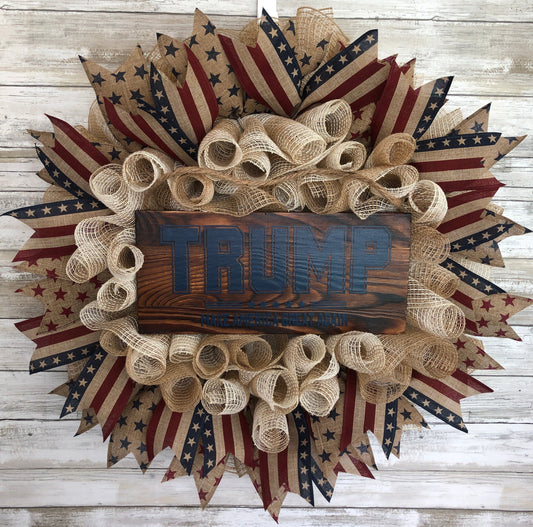 Show your patriotic pride with our handmade door wreath, designed to honor our President Trump and his mission to "Make America Great Again". Enhance your home decor with this high-quality product that adds a masculine touch of patriotic support and inspiration!  The sign at the center of the wreath is a dark pine wood with a dark Navy print. This color combination give it a subtle, sleek look.  American Made. Patriot Made and one of a kind.&nbsp;