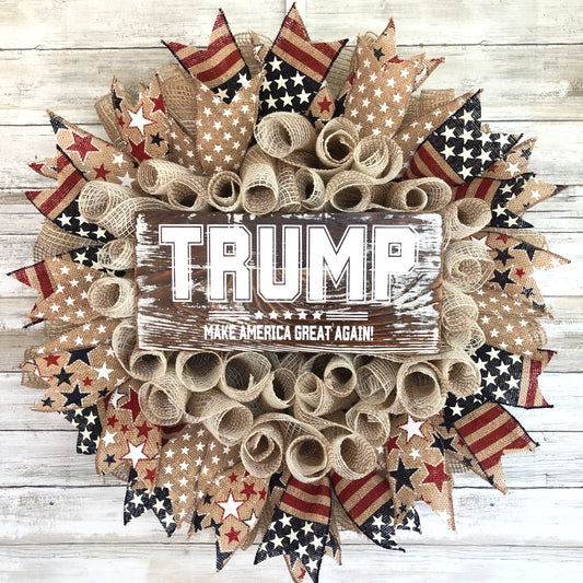 Show your patriotic spirit with the TRUMP Make America Great Again Farmhouse Door Wreath. This beige base wreath features burlap ribbon and a red, white, and blue star design. Choose from three different color options for the Trump sign: red, white, or blue. Make a bold statement and inspire others with this American flag inspired wreath.  American Made. Patriot Made and one of a kind. Cataldo Creations