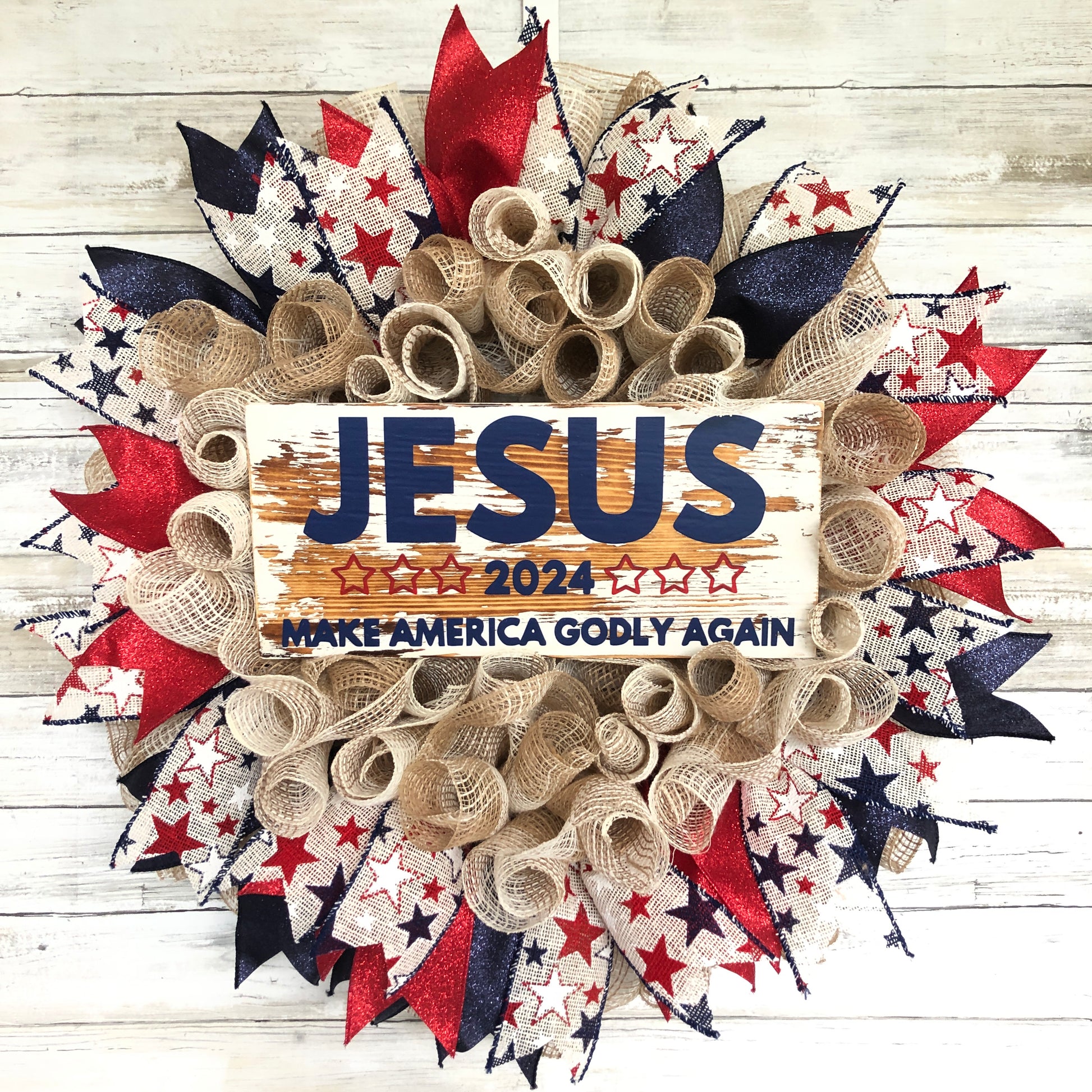 Celebrate your faith and patriotism with this handmade door wreath featuring the message "Jesus 2024 Make America Godly Again." The vibrant blue and red glitter ribbon add a festive touch. Show your support for a godly America in the upcoming election.