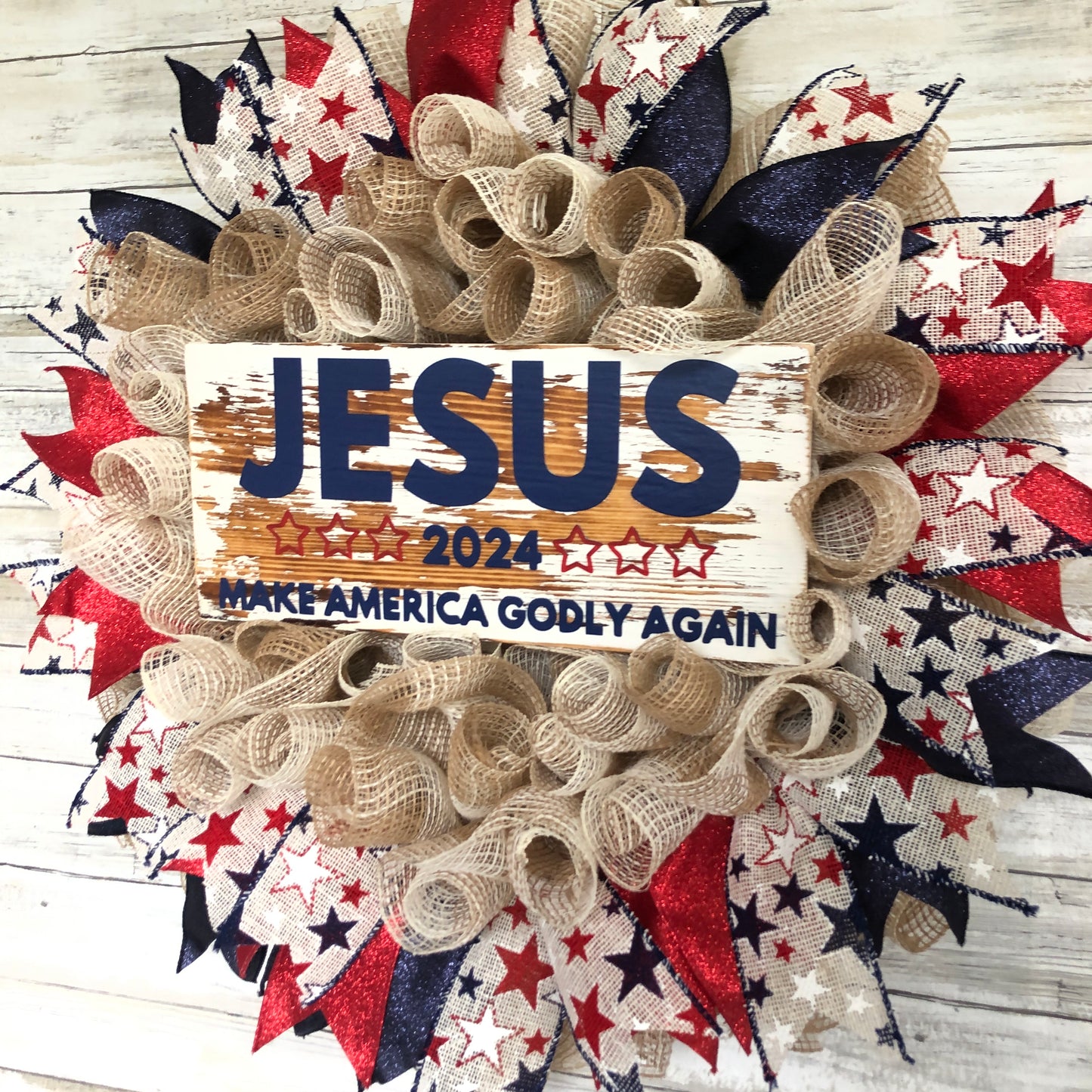 Celebrate your faith and patriotism with this handmade door wreath featuring the message "Jesus 2024 Make America Godly Again." The vibrant blue and red glitter ribbon add a festive touch. Show your support for a godly America in the upcoming election.