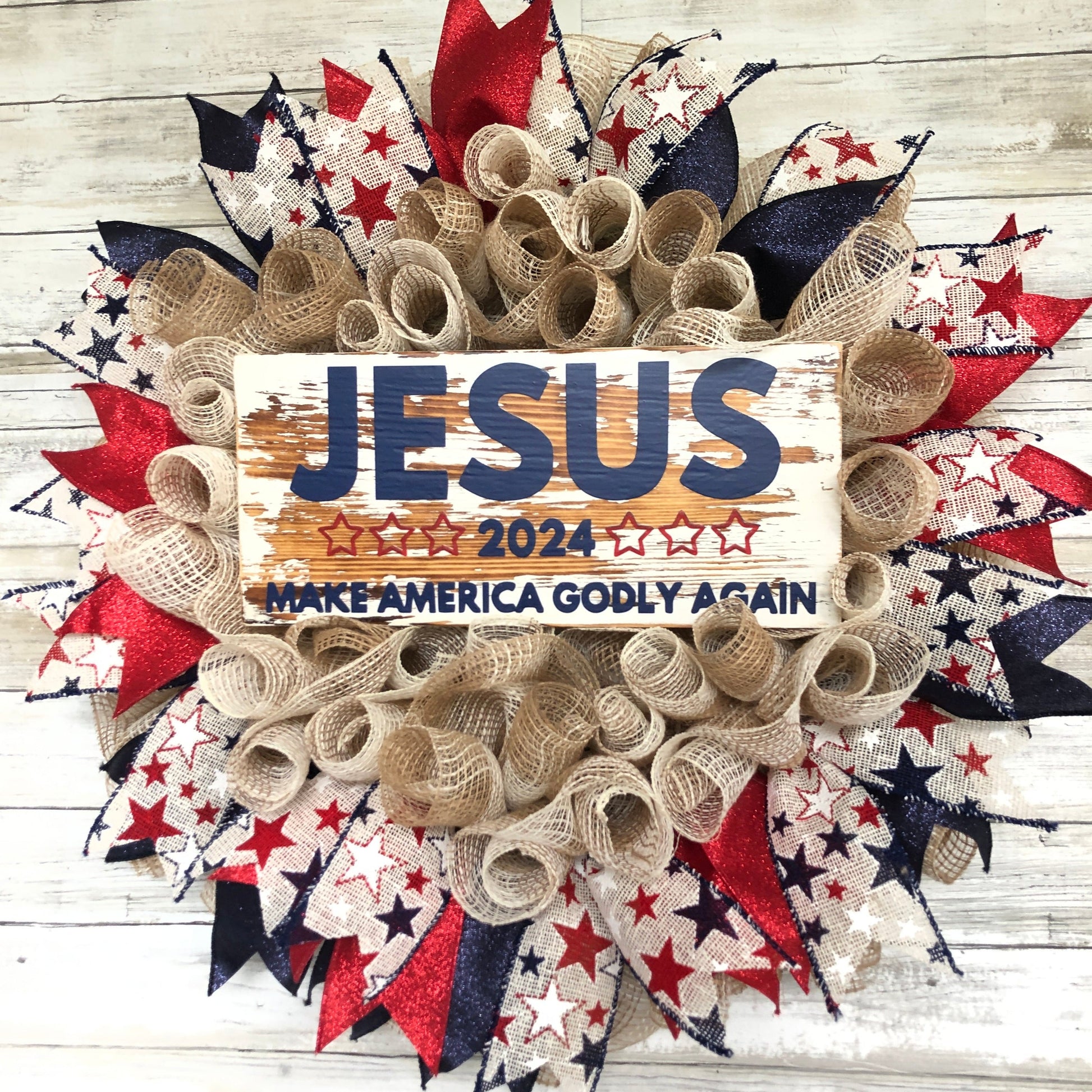 Celebrate your faith and patriotism with this handmade door wreath featuring the message "Jesus 2024 Make America Godly Again." The vibrant blue and red glitter ribbon add a festive touch. Show your support for a godly America in the upcoming election.