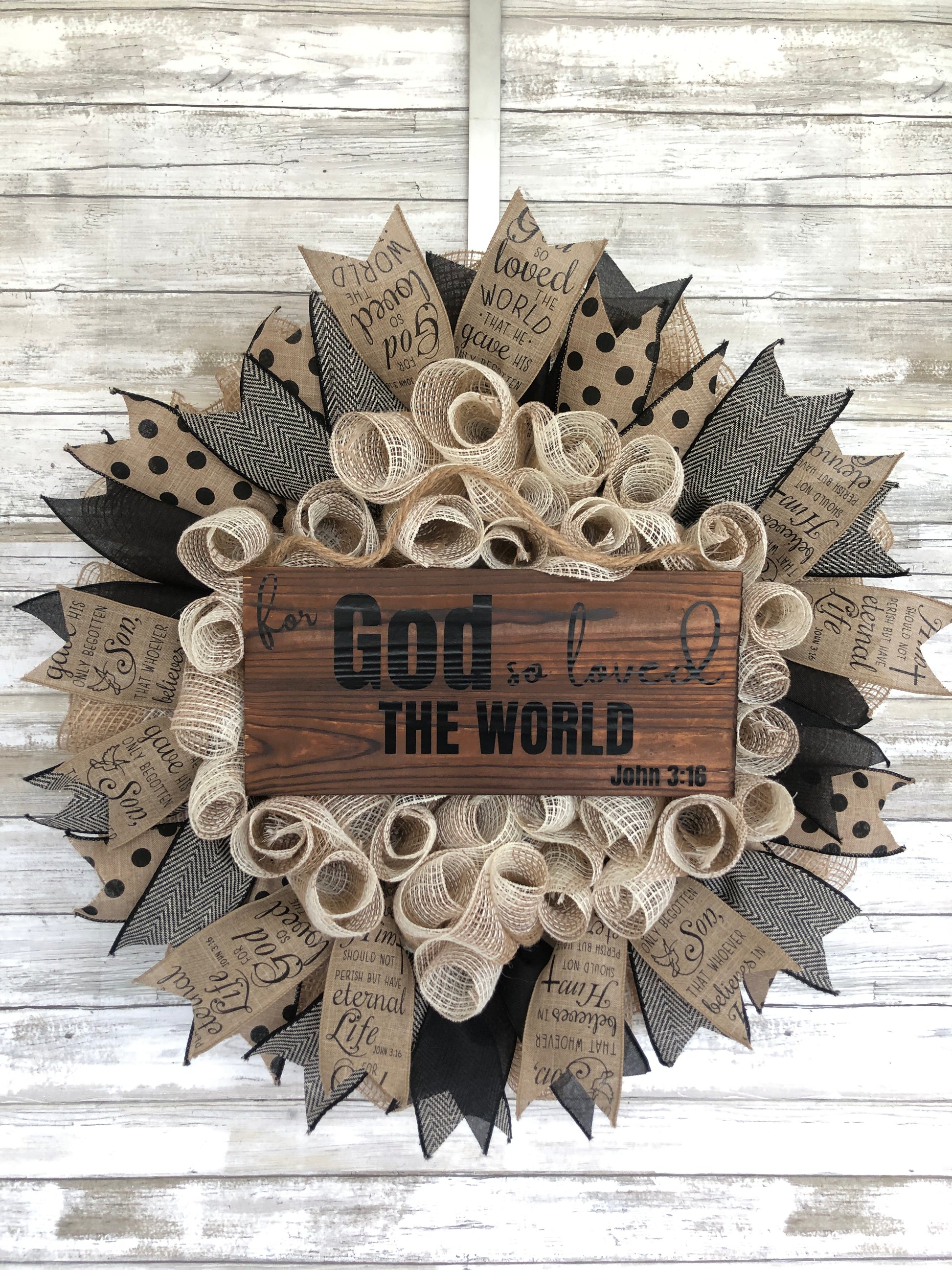 For God so loved the world, that he gave his only begotten Son, that whoever should believe in Him, will not perish, but have everlasting life. John 3:16. This beige and black wreath features ribbon with the John 3:16 scripture and a pine sign centered on the wreath containing the very first section of this bible verse. "For God so loved the world" John 3:16. Cataldo Creations Handmade Door Wreath. Christian Door Wreath. Christian Door Decor.