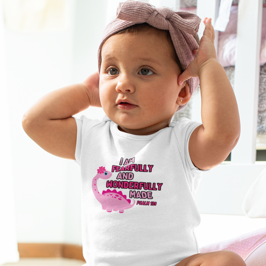 Celebrate the arrival of your newborn girl with our adorable pink dinosaur bodysuit. Made with a soft 100% cotton fabric, this onesie is perfect for your little one's delicate skin. With the bible verse Psalm 139:14, "I am fearfully and wonderfully made," it serves as a reminder of your precious baby's uniqueness.