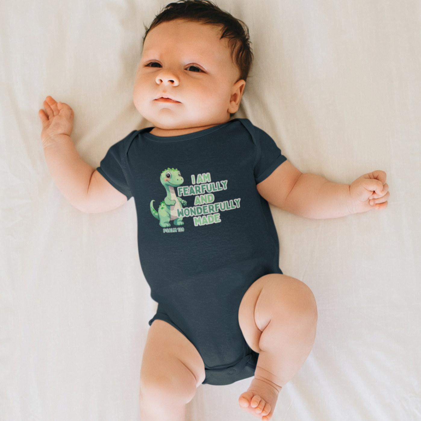 Introduce your little one to the world with our Fearfully Made Green Dinosaur Infant Bodysuit Onesie. Featuring a bible verse from psalm 139:14, this bodysuit reminds us that we are all fearfully and wonderfully made. Made for infants, this bodysuit is both comfortable and meaningful. Cataldo Creations