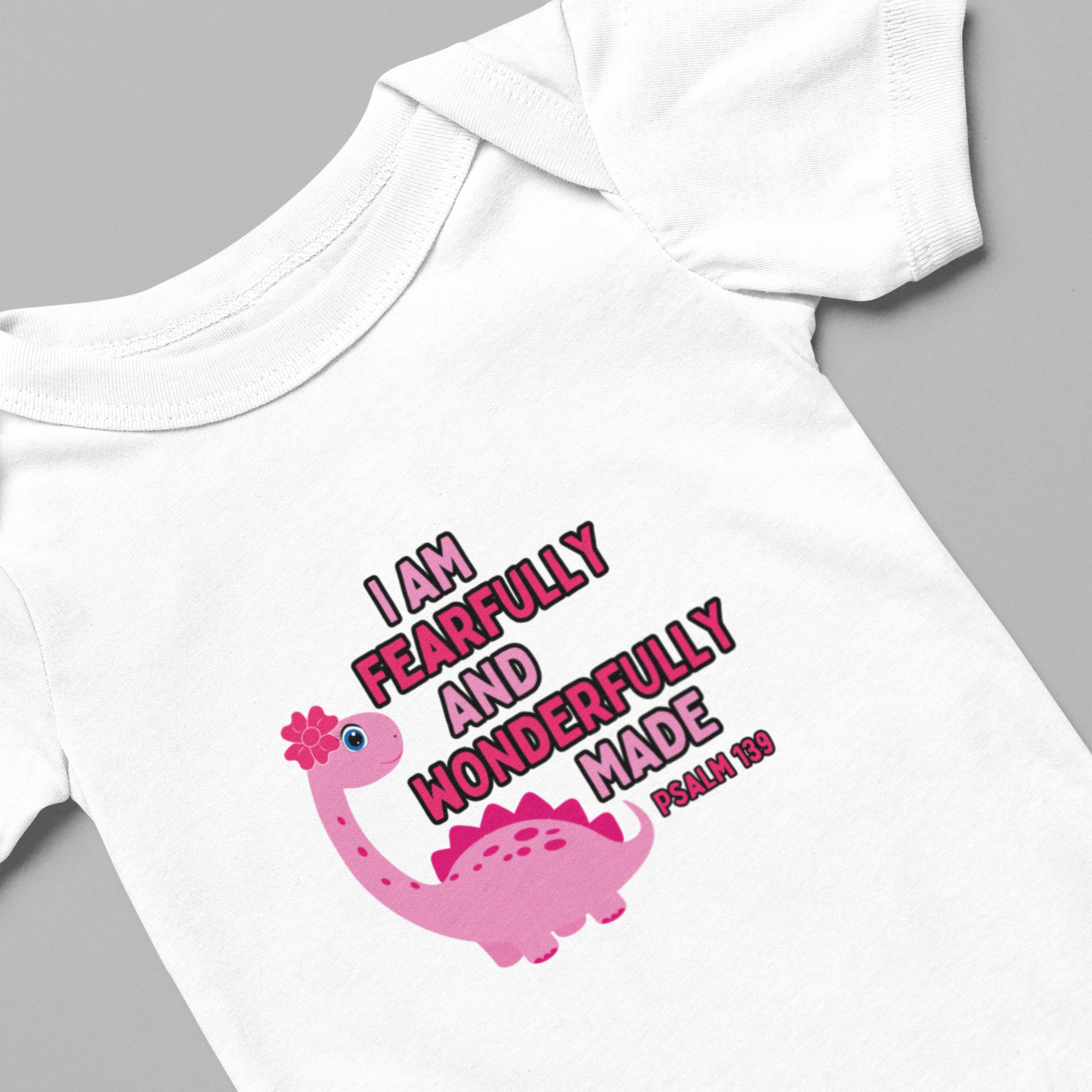 Celebrate the arrival of your newborn girl with our adorable pink dinosaur bodysuit. Made with a soft 100% cotton fabric, this onesie is perfect for your little one's delicate skin. With the bible verse Psalm 139:14, "I am fearfully and wonderfully made," it serves as a reminder of your precious baby's uniqueness. Cataldo Creations