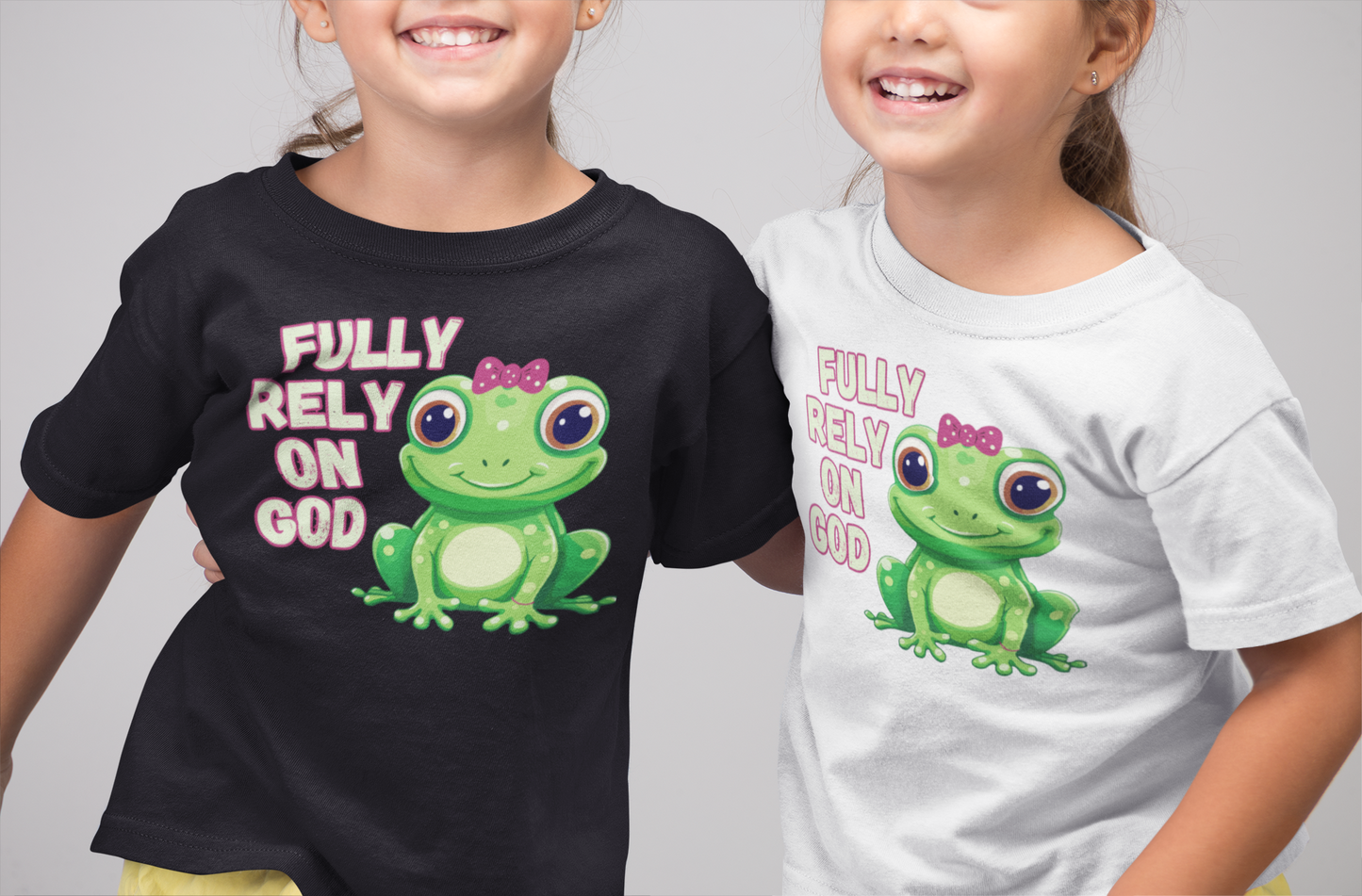 FROG. Fully Rely On God. This cute little girl toddler short sleeve t-shirt has an adorable green frog wearing a pink bow.&nbsp; Alongside are the words Fully Rely On God in light green and pink lettering. Perfect for your toddler girl! Christian toddler tee. Cataldo Creations apparel for toddlers